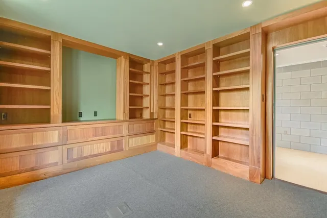 a view of an empty room with cabinet and a window