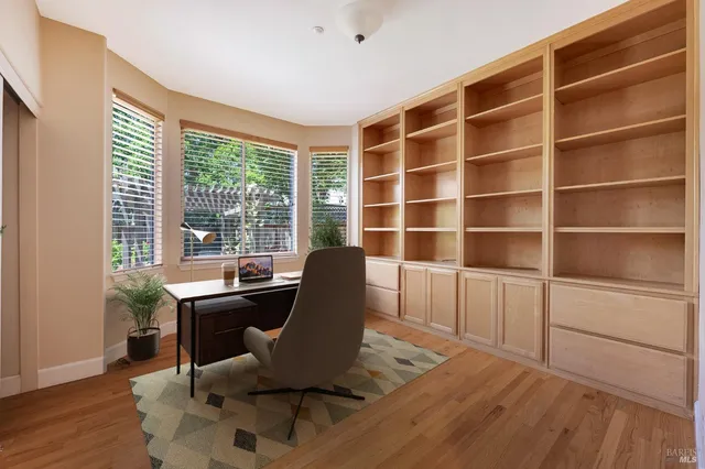 a view of a workspace with furniture and a window