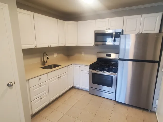 a kitchen with white cabinets and stainless steel appliances