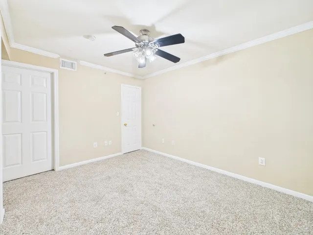 an empty room with a window and a fan
