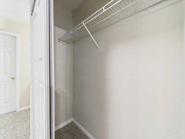 an empty room with windows and ceiling fan