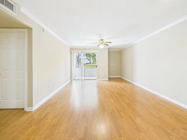 a view of an empty room with wooden floor