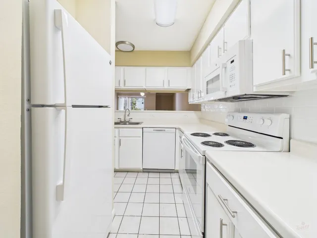 a kitchen with white cabinets and white appliances