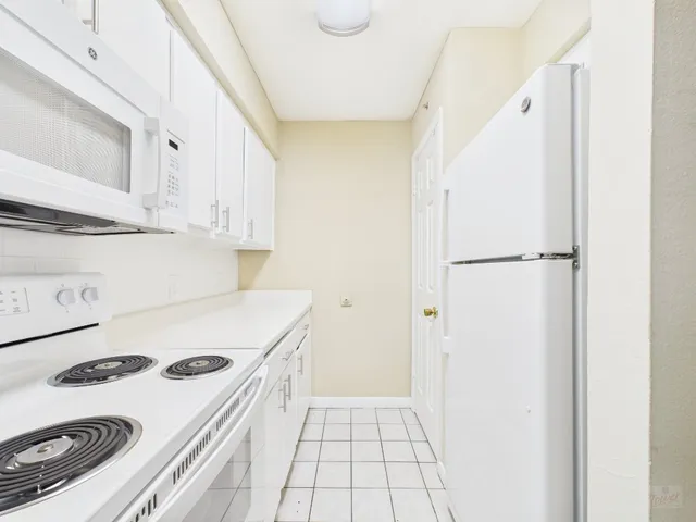 a kitchen with a white stove top oven and white countertops