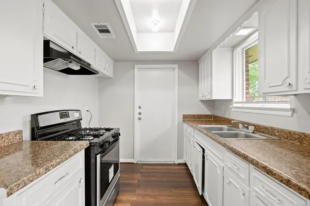 a kitchen with stainless steel appliances granite countertop a sink stove and refrigerator