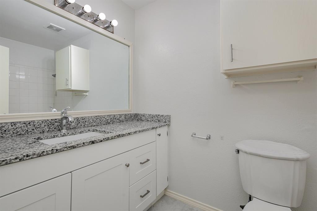 12480 Abrams Road, Unit 723 Dallas, TX 75243 - Photo 16 of 19 a bathroom with a granite countertop sink a toilet and mirror