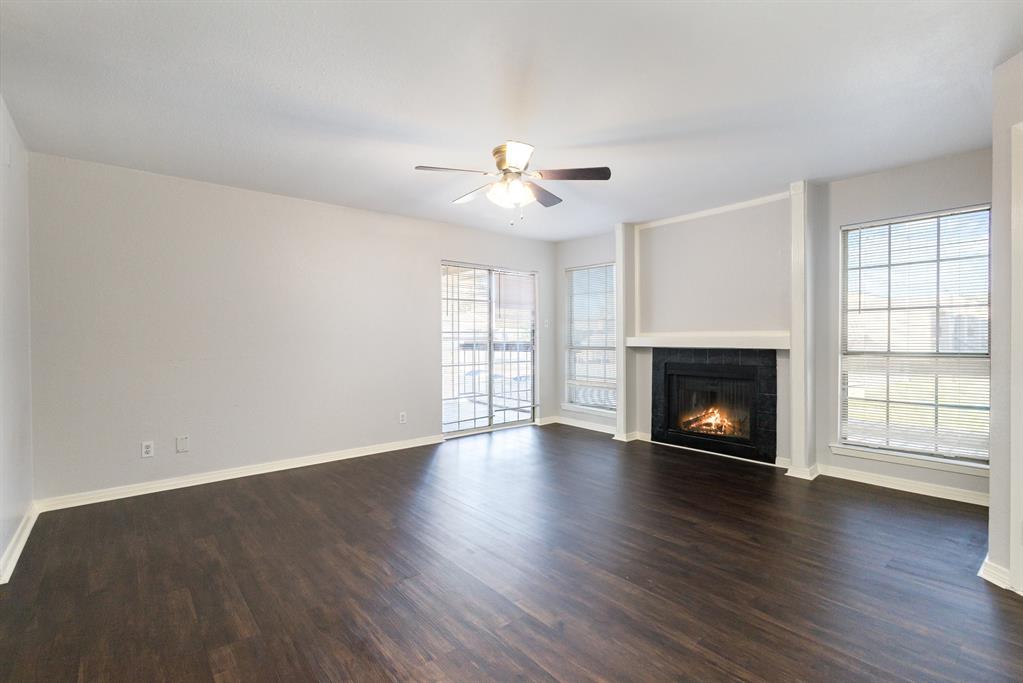 12480 Abrams Road, Unit 723 Dallas, TX 75243 - Photo 5 of 19 an empty room with windows fireplace and wooden floor