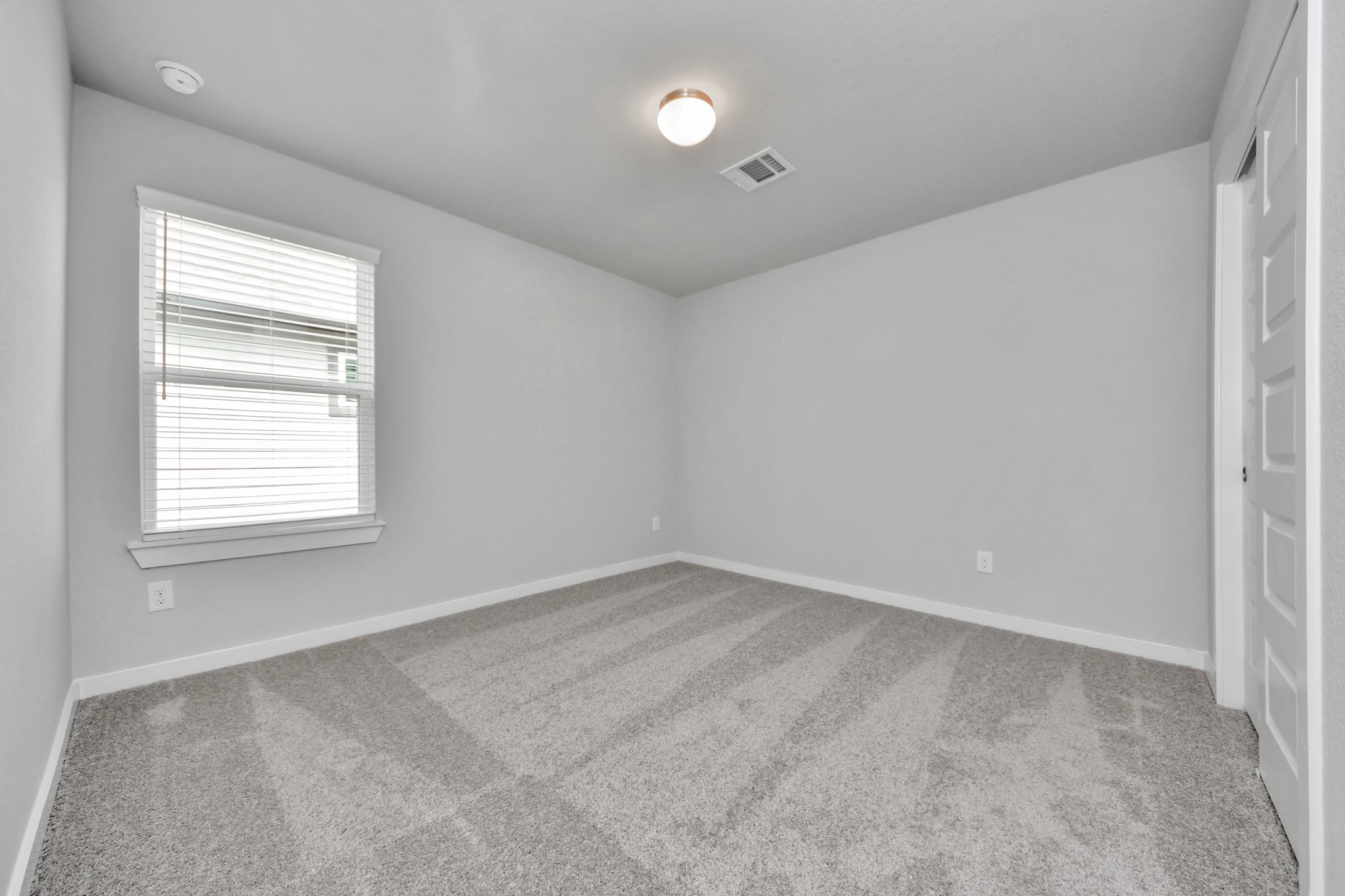 11114 Tulip Rdg Trail Houston, TX 77044 - Photo 29 of 30 Secondary bedroom features plush carpeting, large windows that let in plenty of natural light, bright paint, and spacious closets. Sample photo of completed home with similar floor plan. Actual colors and selections may vary.