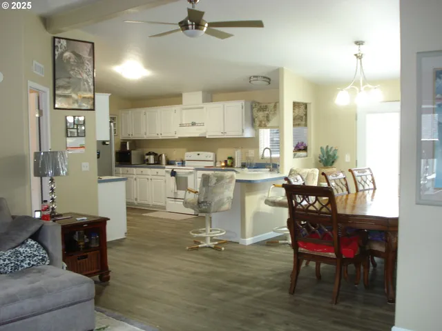 a kitchen with a dining table chairs and white cabinets