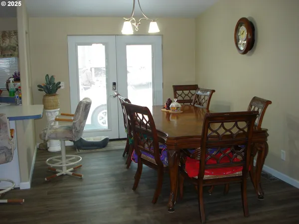 a dining room with furniture a chandelier and wooden floor