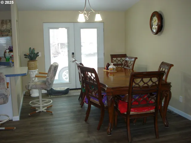a dining room with furniture a chandelier and wooden floor