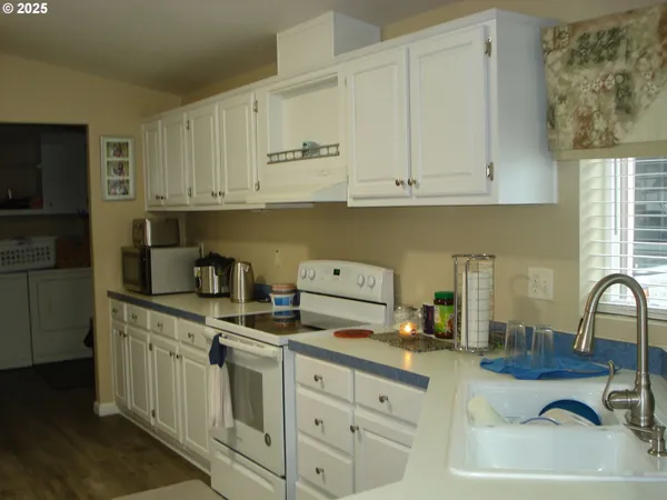 a kitchen with cabinets appliances a sink and a counter top space