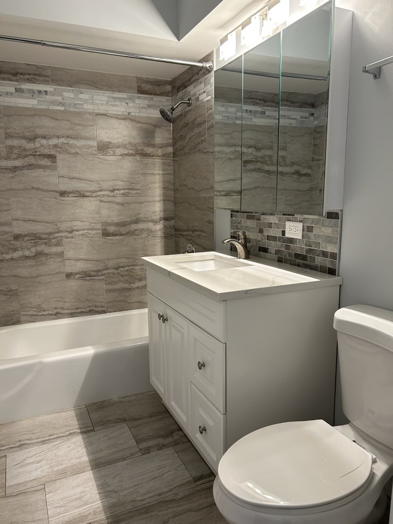 10440 Ridgeland Avenue, Unit 5 Chicago Ridge, IL 60415 - Photo 18 of 22 a bathroom with a sink a toilet and shower