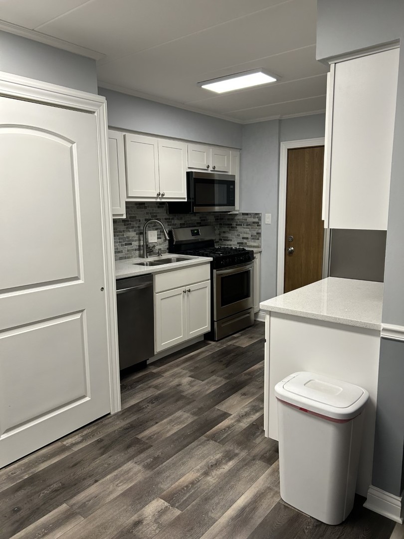 10440 Ridgeland Avenue, Unit 5 Chicago Ridge, IL 60415 - Photo 8 of 22 a bathroom with a toilet a sink and a refrigerator