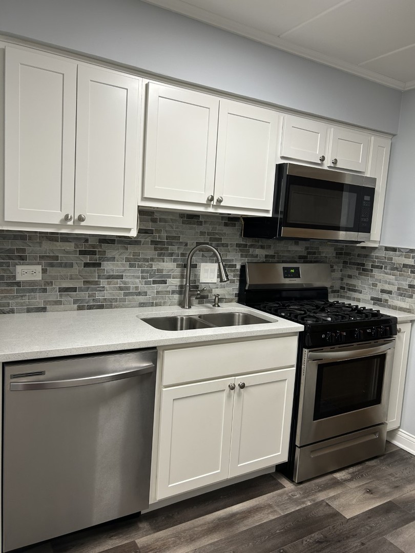 10440 Ridgeland Avenue, Unit 5 Chicago Ridge, IL 60415 - Photo 9 of 22 a kitchen with stainless steel appliances granite countertop grey cabinets a microwave a sink and a counter space