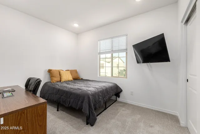 a bedroom with a bed and a flat screen tv