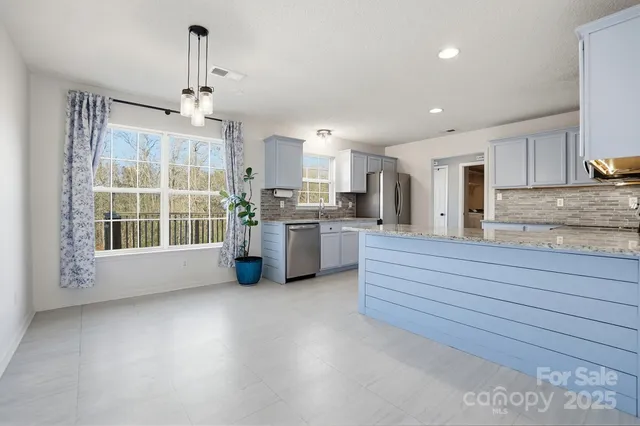 a kitchen with stainless steel appliances granite countertop a stove and a sink