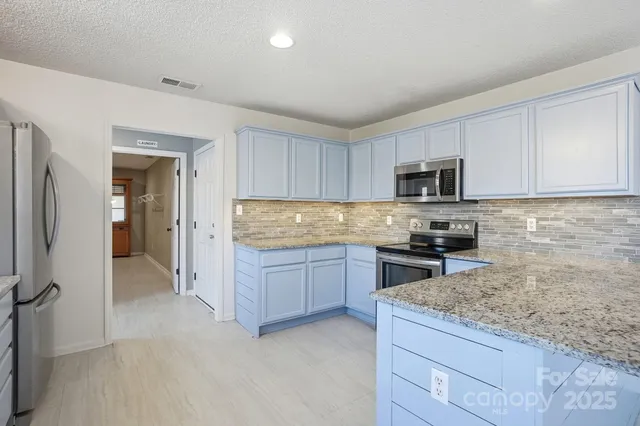 a kitchen with granite countertop a stove sink and cabinets