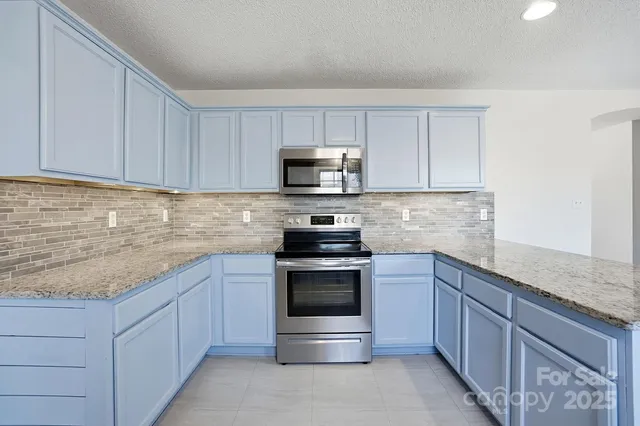 a kitchen with sink a microwave and cabinets