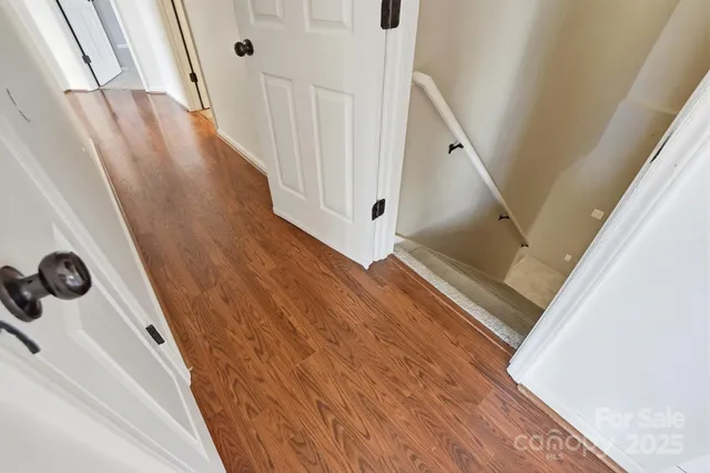 a view of a hallway with wooden floor and staircase
