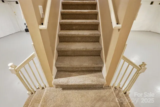 a view of staircase with white walls and a window