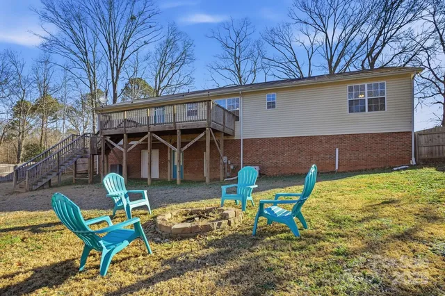 a view of a backyard with chairs and iron fence