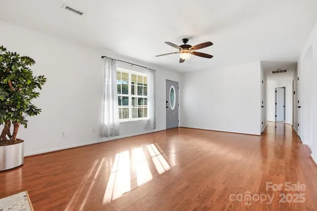 a view of empty room with wooden floor and potted plant