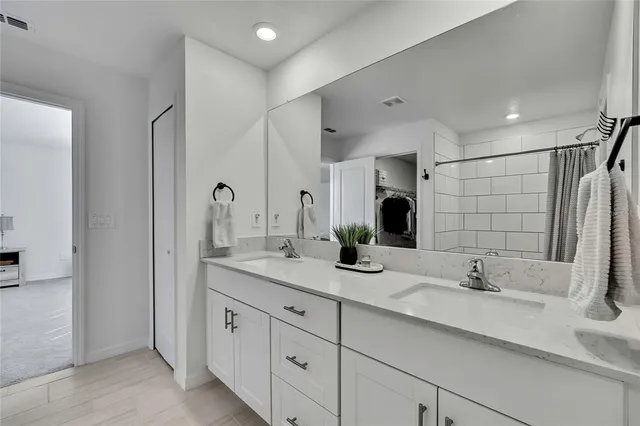 a bedroom with a bed a chandelier and a chair