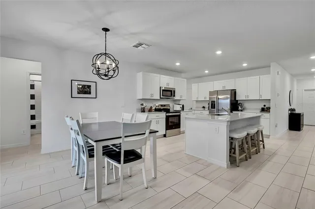 a kitchen with granite countertop a sink stainless steel appliances and white cabinets
