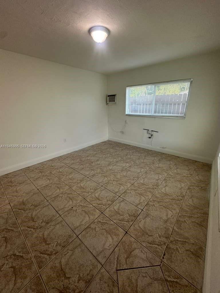 6321 Pembroke Road, Unit 6 Hollywood, FL 33023 - Photo 2 of 11 an empty room with a wooden floor and a window