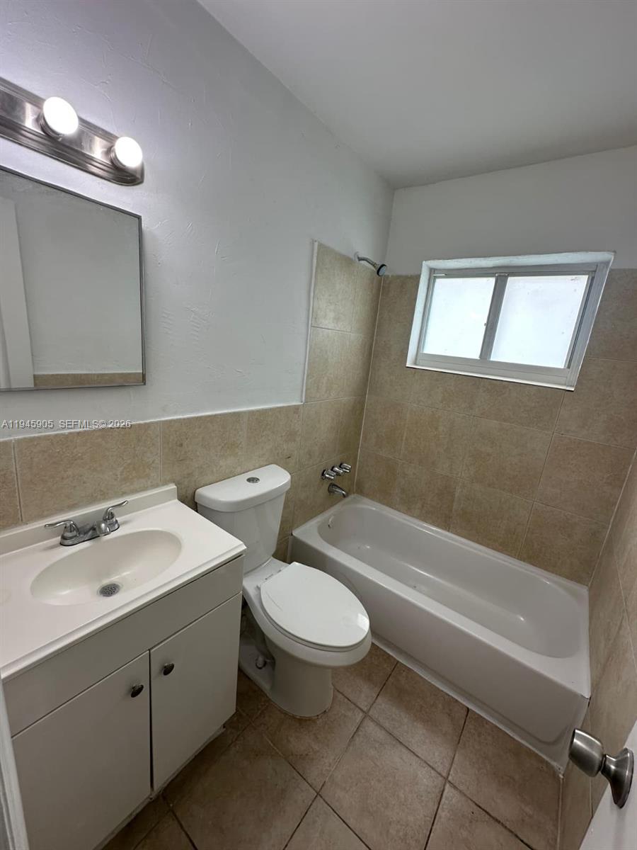 6321 Pembroke Road, Unit 6 Hollywood, FL 33023 - Photo 9 of 11 a bathroom with a double vanity sink toilet and shower