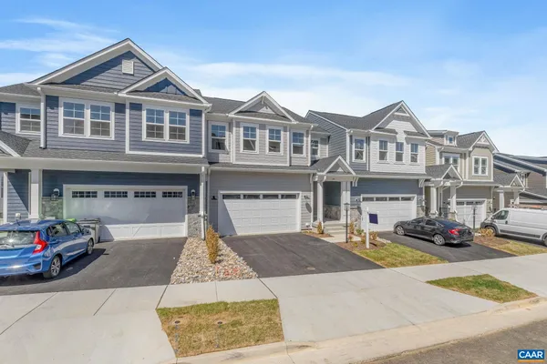 a front view of a house with yard and parking