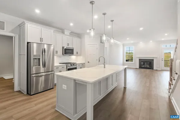 a kitchen with a sink a counter top space stainless steel appliances and wooden floor