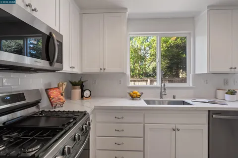 a kitchen with stainless steel appliances granite countertop a sink stove and cabinets