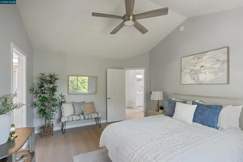 a bedroom with a large bed and a potted plant