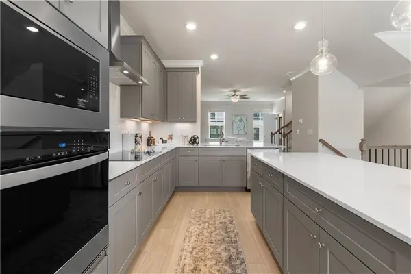 an empty room with wooden floor a ceiling fan and windows