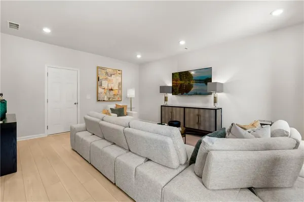 a living room with furniture a window and a flat screen tv