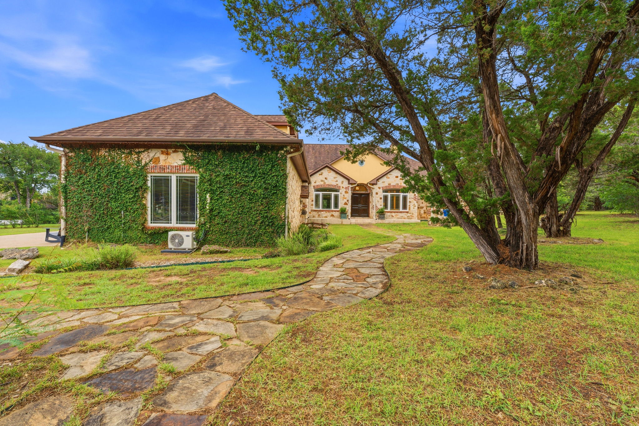 8121 Bluff Trail Austin, TX 78737 - Photo 4 of 40 A winding stone path leads to this unique home, partially covered in verdant climbing vines.