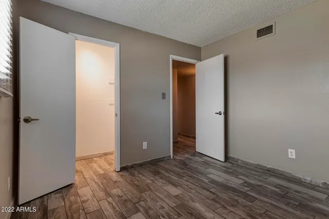 an empty room with wooden floor and closet