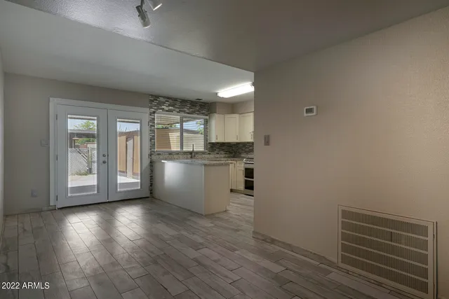 a view of a kitchen with wooden floor and a window