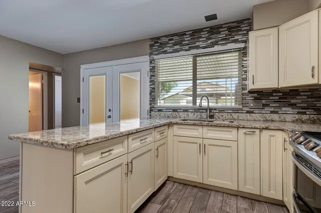 a kitchen with granite countertop a sink and white cabinets