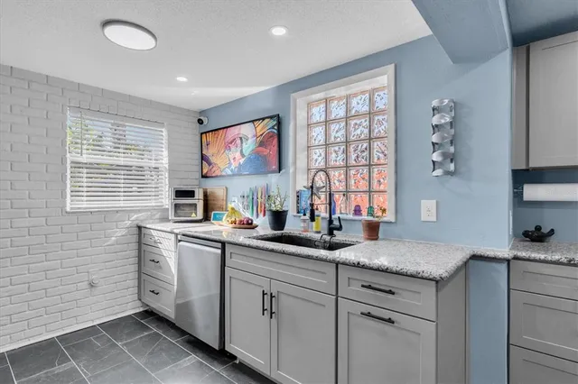 a kitchen with stainless steel appliances granite countertop a sink and a window