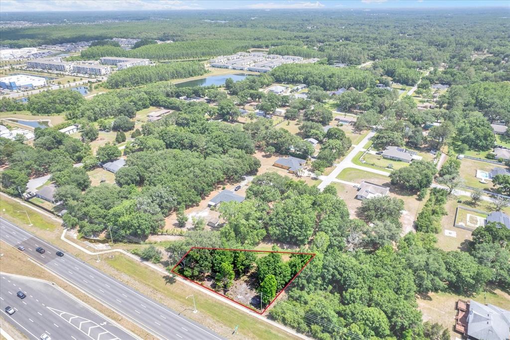 an aerial view of residential houses with outdoor space and trees