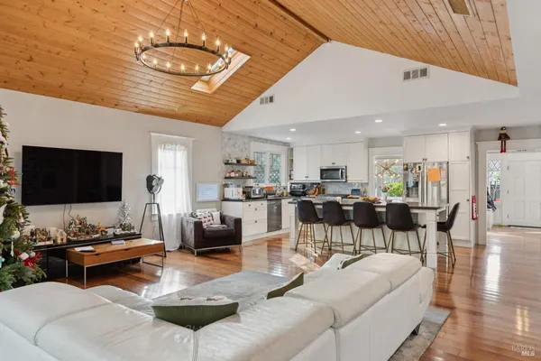 a living room with furniture kitchen view and a large window