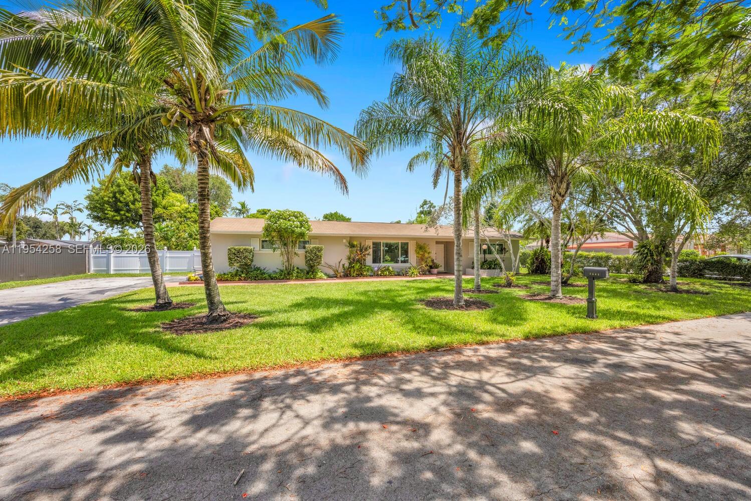 9841 Southwest 122nd Street Miami, FL 33176 - Photo 1 of 1 a view of a house with a big yard and palm trees