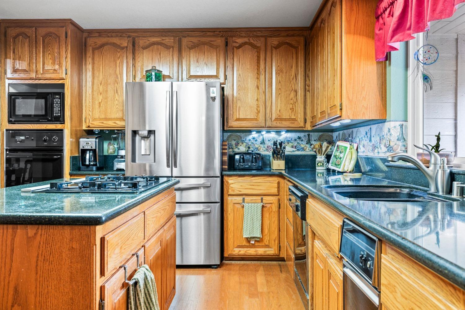 6432 Happy Valley Road Somerset, CA 95684 - Photo 46 of 90 a kitchen with stainless steel appliances granite countertop a stove a sink and a refrigerator