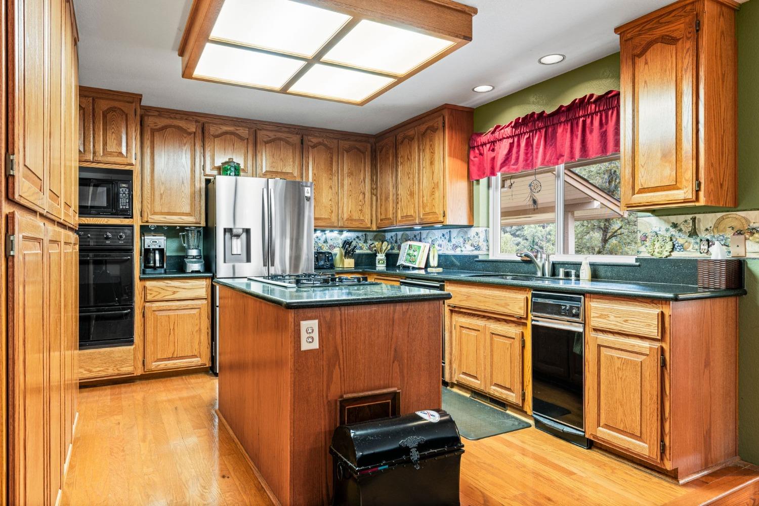 6432 Happy Valley Road Somerset, CA 95684 - Photo 49 of 90 a kitchen with stainless steel appliances granite countertop a stove a sink and a refrigerator