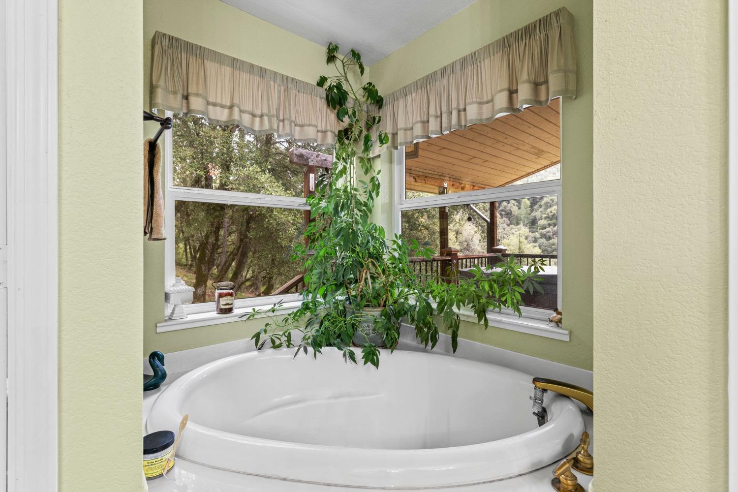 6432 Happy Valley Road Somerset, CA 95684 - Photo 56 of 90 a white bath tub sitting in a bathroom next to a window