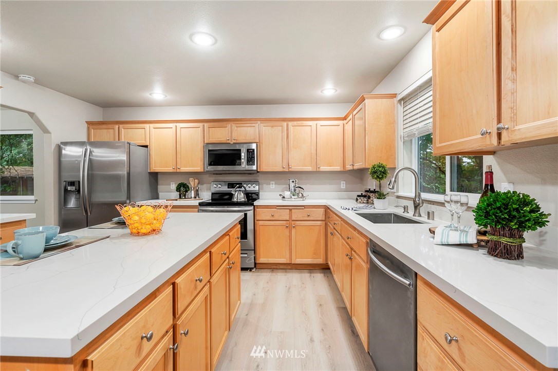 6719 Southeast 5th Street Renton, WA 98059 - Photo 9 of 29 a kitchen with stainless steel appliances a sink dishwasher a refrigerator a stove top oven a counter space and cabinets