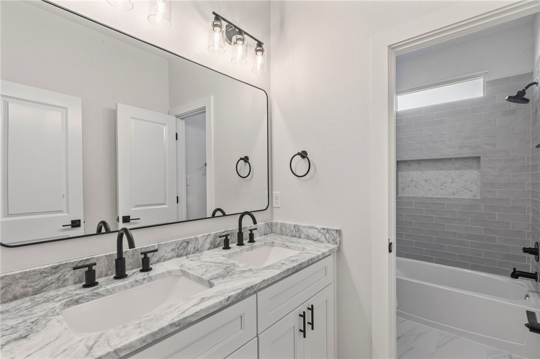 2102 Joppi Court Bryan, TX 77807 - Photo 13 of 27 a bathroom with a granite countertop sink and a mirror